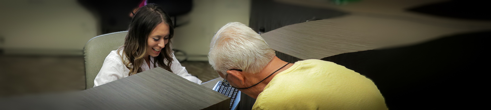 A teller assists a customer with a banking transaction.